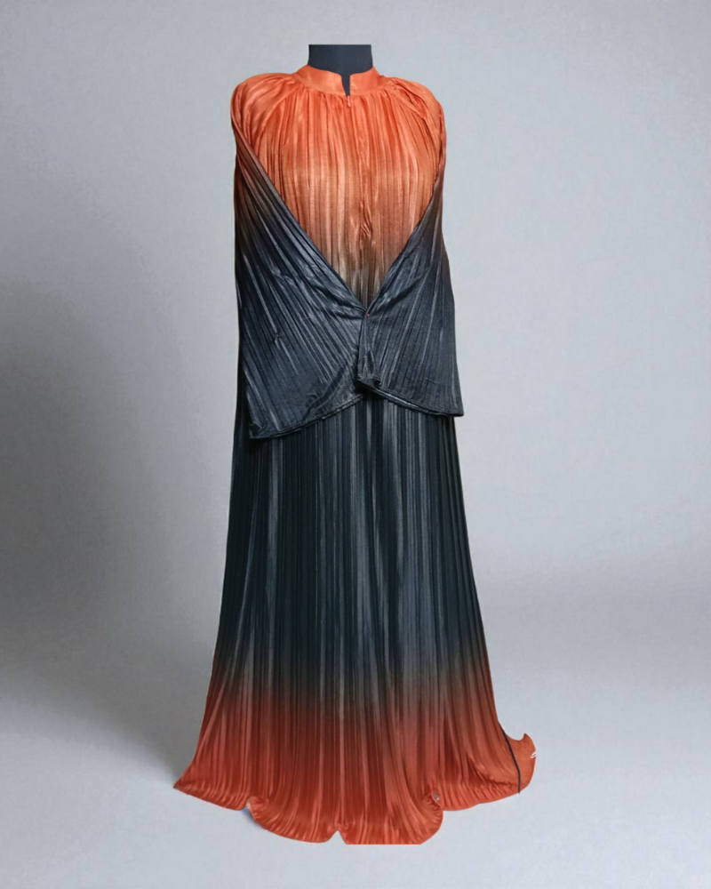The Pleated Cascade Abaya in sunset haze. An elegant, silky abaya with an orange to black gradient and full-length pleats. Perfect for evening wear.